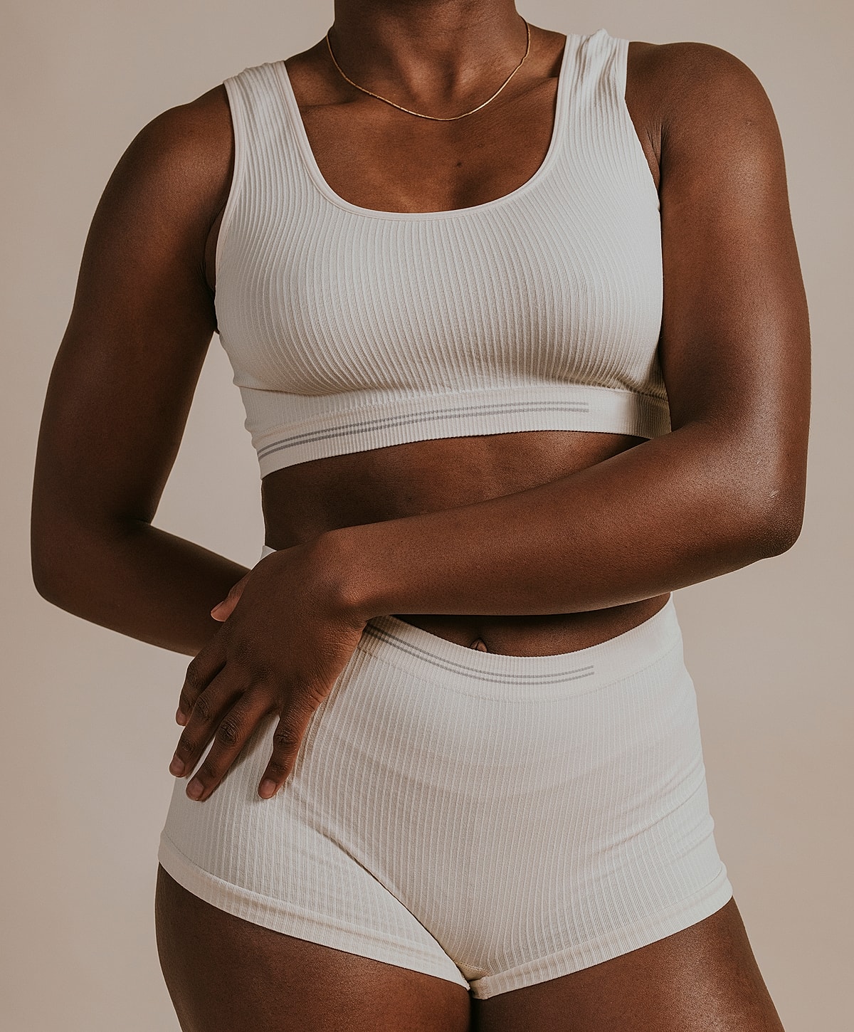 Model in cream ribbed activewear set.
