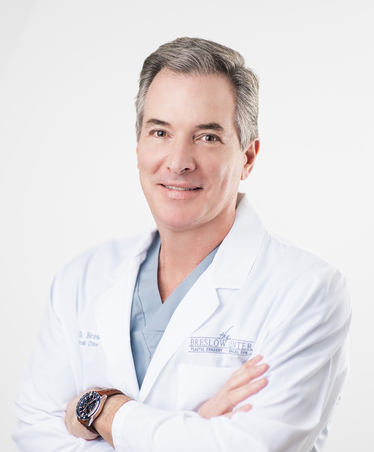 Male doctor in a white coat, smiling confidently.
