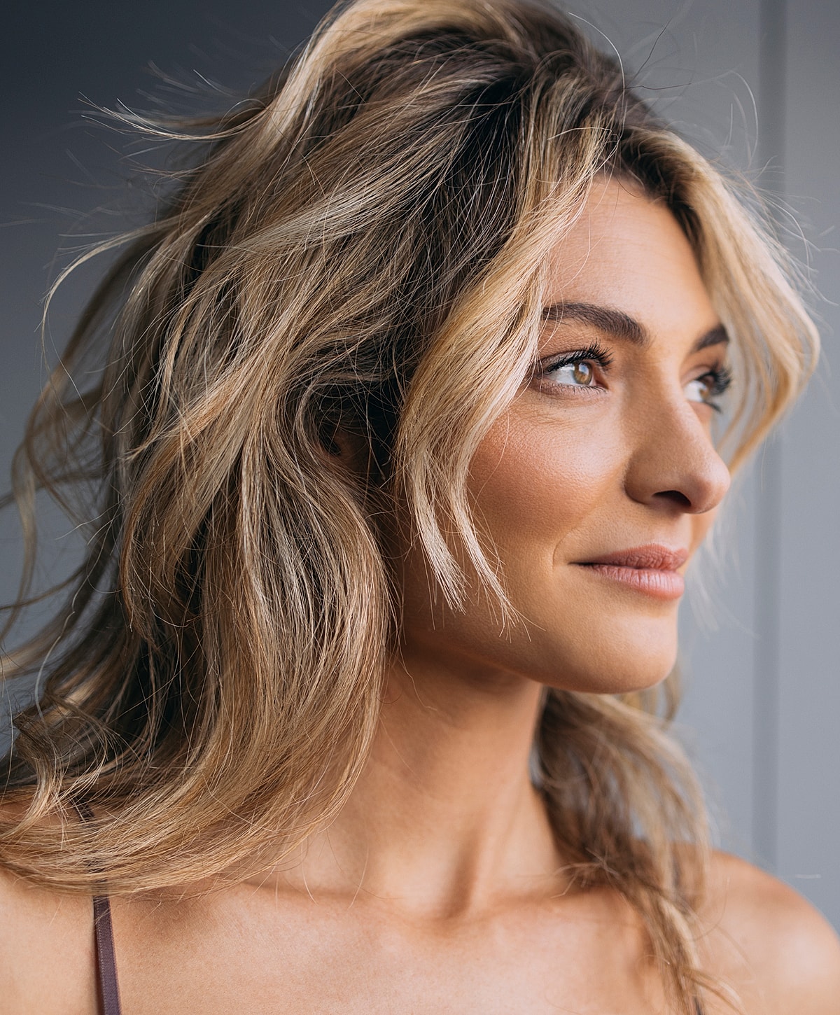 Woman with wavy hair, profile view, natural makeup.