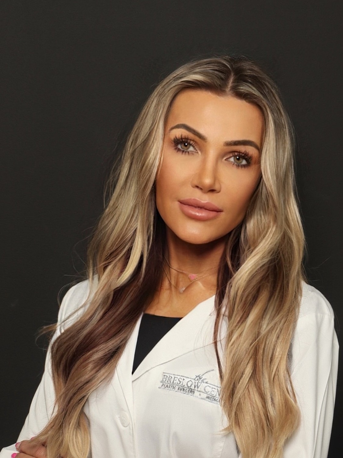 Smiling professional in white lab coat portrait.