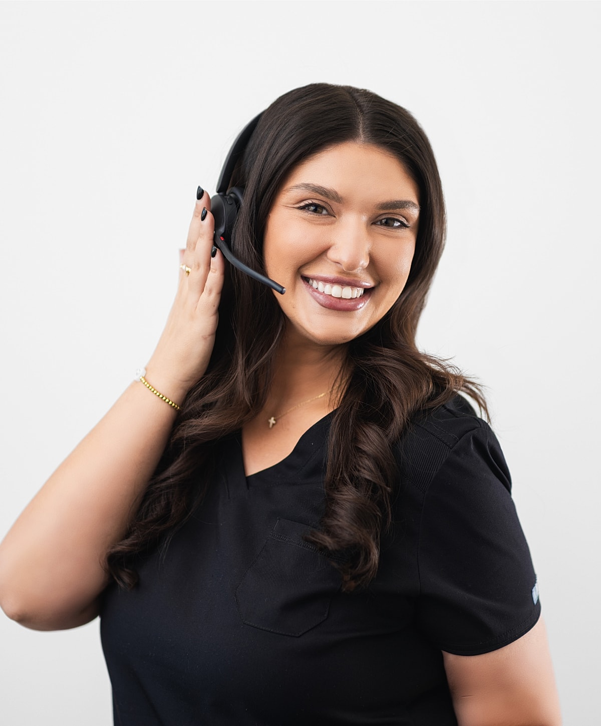 Woman in headset holding clipboard, smiling at camera.
