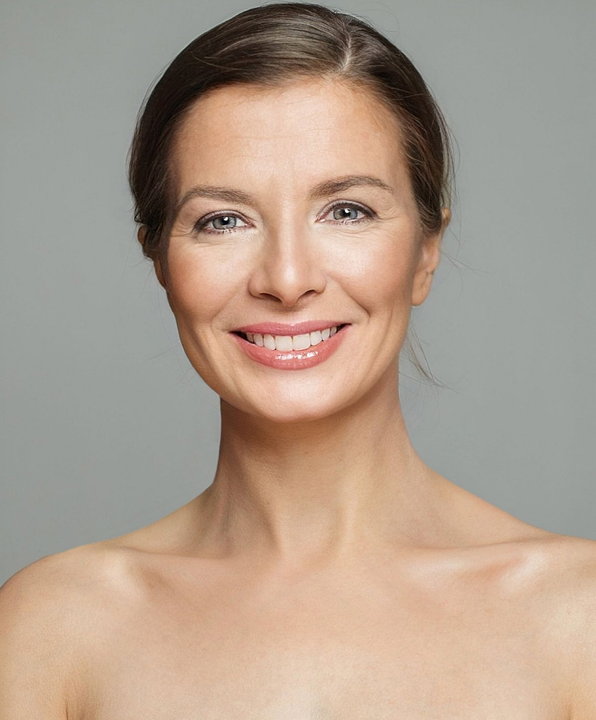 Smiling woman with natural makeup and neutral background