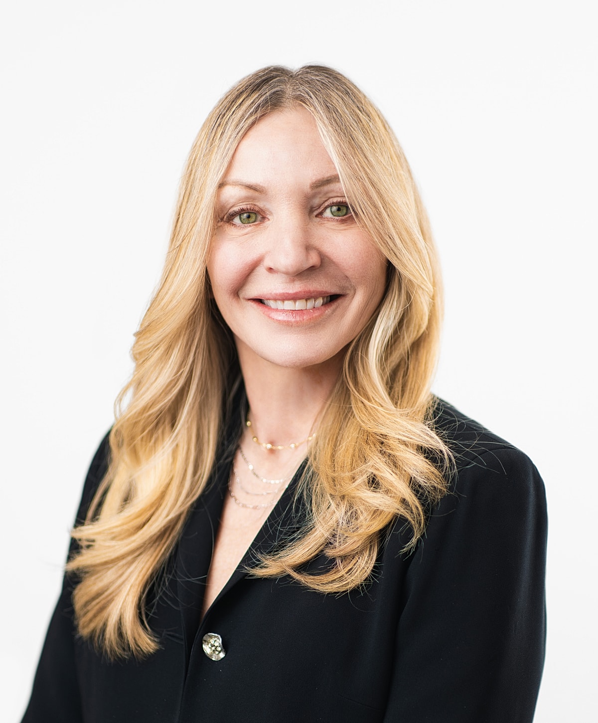 Smiling woman in professional attire against white background.
