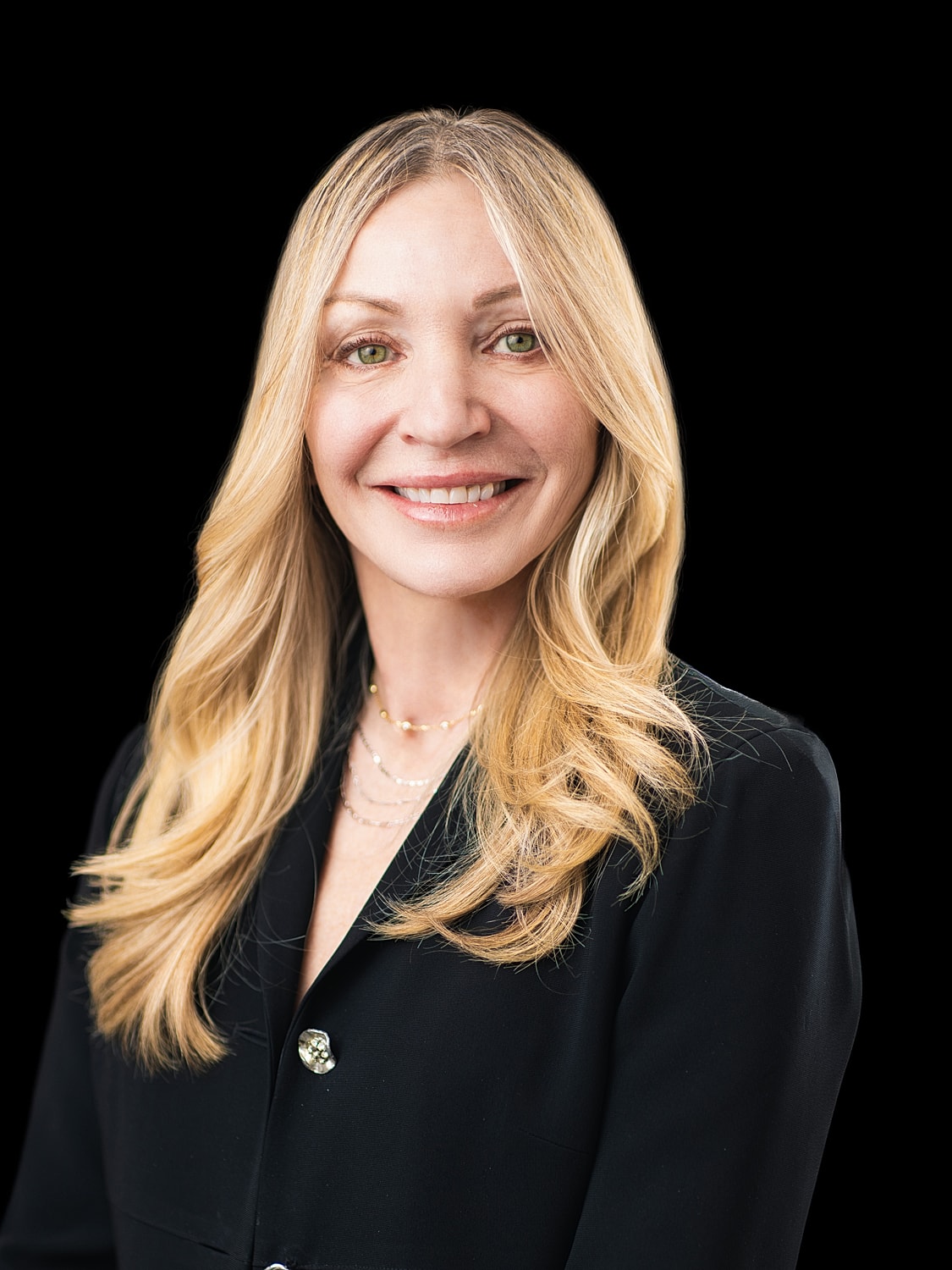 Smiling woman with long, blonde hair in black attire.