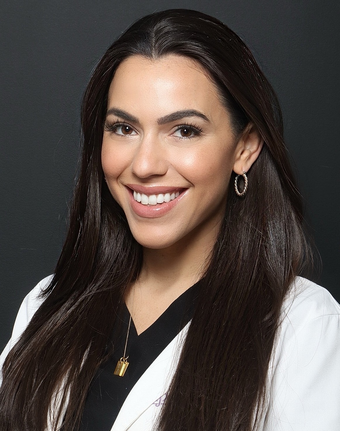 Smiling woman in a healthcare professional's attire.