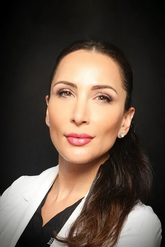Paramus medspa provider in white coat, confident expression.