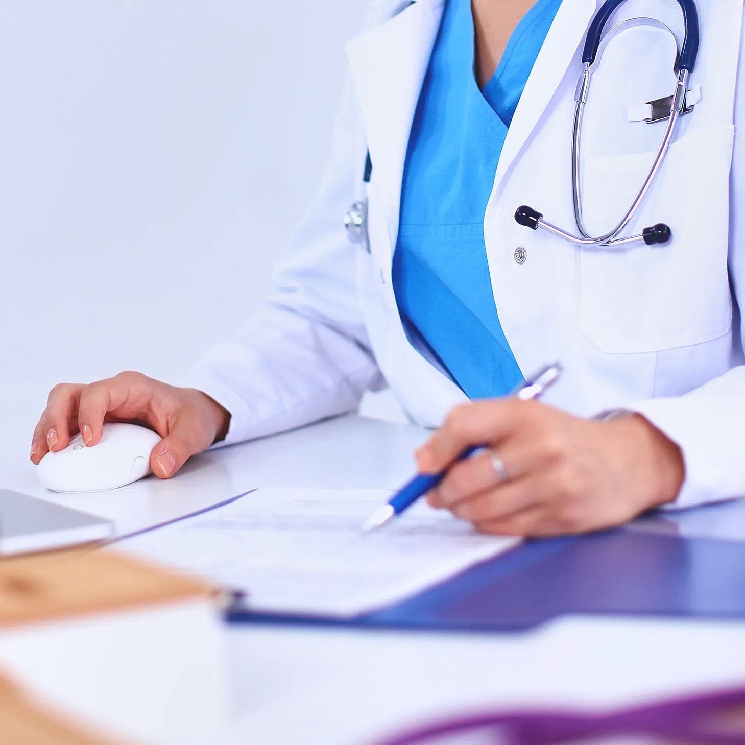 Medical professional writing notes at a desk.