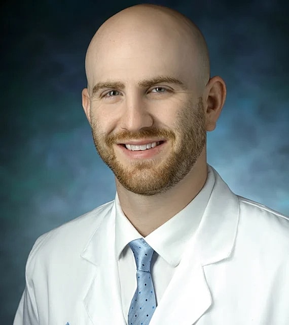 Smiling male doctor in white coat and tie