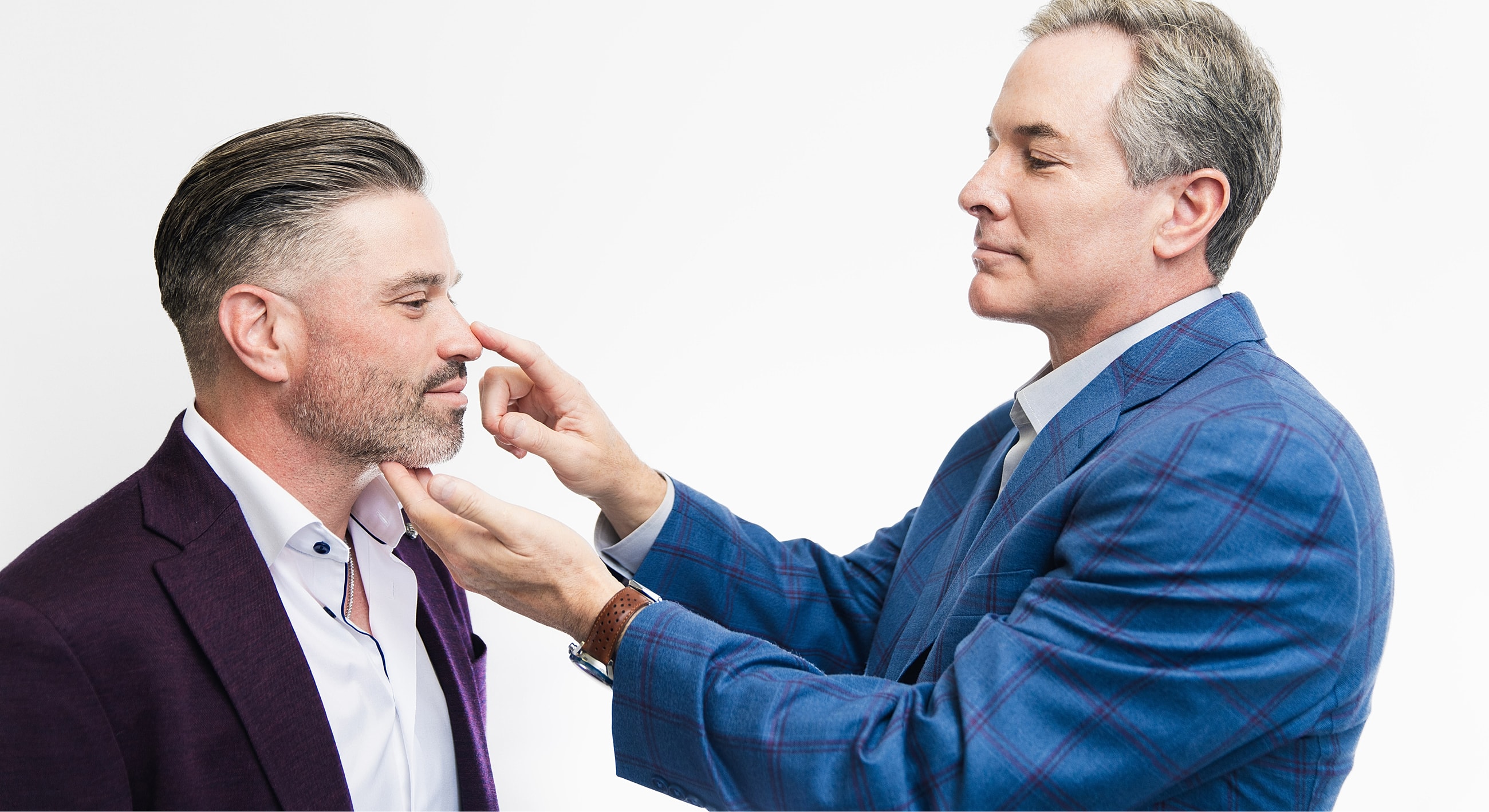 Two men discussing grooming or styling options.